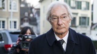 Alter, hagerer Mann. Er schaut ins Bild. Hinter ihm steht eine Frau mit TV-Kamera. Alter, hagerer Mann. Er schaut ins Bild. Hinter ihm steht eine Frau mit TV-Kamera.