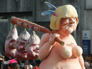 Angela Merkel als Pappfigur beim Düsseldorfer Karneval 2004 mit den Skalps von Stoiber, Koch und Merz.