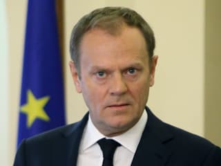 Der EU-Ratspräsident schaut nachdenklich in die Kamera, hinter ihm ist eine EU-Flagge zu sehen