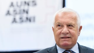 Klaus in einer Porträtaufnahme. Im Hintergrund gross das Auns-Logo. Klaus in einer Porträtaufnahme. Im Hintergrund gross das Auns-Logo.