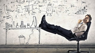 Mann auf Bürostuhl mit Comic im Hintergrund