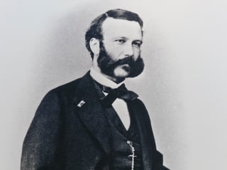Schwarzweiss-Bild von Henry Dunant mit Bart und Anzug