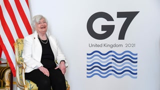 Frau, die lacht, vor einer US-Fahnen und dem Logo der G7. Frau, die lacht, vor einer US-Fahnen und dem Logo der G7.