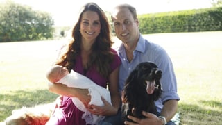 Kate mit Baby George auf dem Arm, daneben William mit einem Hund Kate mit Baby George auf dem Arm, daneben William mit einem Hund