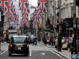 New Bond Street in London, schwarze Taxis auf der Strasse, Union Jacks hängen über der Fahrbahn.