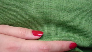 Eine Frau hält sich eine Hand an den Bauch. Eine Frau hält sich eine Hand an den Bauch.