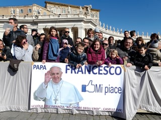 Papst-Fans auf dem Petersplatz. Vor ihnen ein Banner. Darauf steht: Papst Franziskus - gefällt mir.