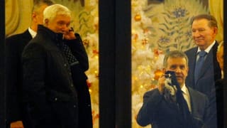 Russische Botschafter und Leonid Kutschma stehen hinter einem Fenster.