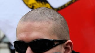 Skinhead vor NPD-Fahne