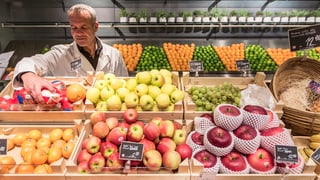 Ein Mann schaut Früchte an.