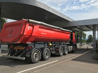 Ein roter Lastwagen durchfährt das Zollamt