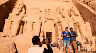 Touristen fotographieren sich vor dem Eingang zum Tempel