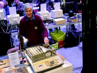 Mann präsentiert einen alten Computer.