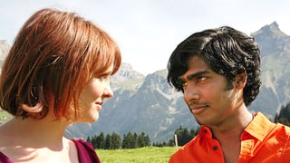 Leo und Devan stehen vor einem Bergpanorama und schauen sich in die Augen.
