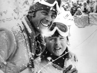 Schwarz-weiss Fotografie mit Adolf Ogi und Marie-Theres Nadig im Schneetreiben.