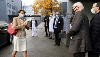 Simonetta Sommaruga geht mit Mundschutz vor dem Berner Inselspital auf Regierungspräsident Pierre Alain Schnegg zu.
