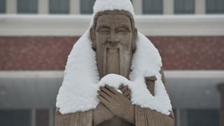 Eine schneebedeckte Statue von Konfuzius. Eine schneebedeckte Statue von Konfuzius.