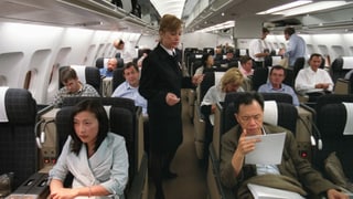 Kabinenpersonal in einem mit Passagieren besetzten Flugzeug.