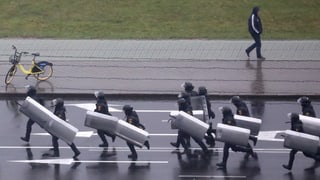 Polizeikräfte gegen in Minsk geben Demonstrierende vor.