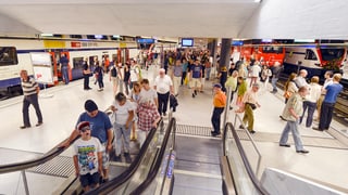 Pendler und Pendlerinnen auf dem Perron und auf der Rolltreppe im neuen Bahnhof Löwenstrasse. 