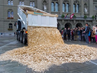 Ein Lastwagen schüttet Fünfräppler auf den Bundesplatz in Bern.