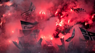 Aufnahme auf einen Fan-Sektor, zahlreiche Pyros brennen, Rauch roter Fackelschein und Fahnen sind zu sehen.