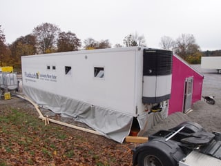 Der Anhänger eines grossen Lastwagens, ein Vorzelt ist daran angebaut.