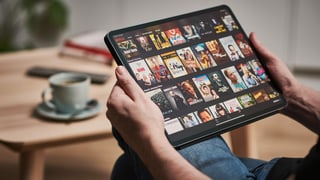 eine Person sucht auf dem iPad einen Netflix-Film
