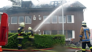 Brand Mehrfamilienhaus in Niederlenz 2012, im Bild Feuerwehrleute und ein Brandermittler