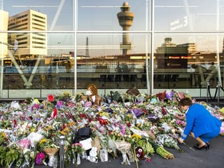 Eine Frau legt Blumen am Amsterdamer Flughafen Schiphol nieder. Seit dem Absturz der Boeing in der Ostukraine ist er zum nationalen Denkmal geworden.
