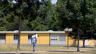 Mann geht auf Bundesasylzentrum Embrach (Gelbe Baracke) zu. Mann geht auf Bundesasylzentrum Embrach (Gelbe Baracke) zu.