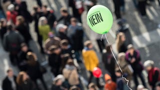 Ein gelber Ballon mit dem Schriftzug «Nein» schwebt über einer Menschenmenge, Blick von oben. Ein gelber Ballon mit dem Schriftzug «Nein» schwebt über einer Menschenmenge, Blick von oben.