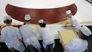 Junge Bäcker kreieren einen riesigen Spitzbueb.