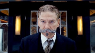 Hercule Poirot steht mit gezwirbeltem Bart vor einem erleuchteten Fenster. Hercule Poirot steht mit gezwirbeltem Bart vor einem erleuchteten Fenster.
