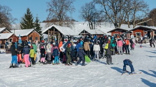 Junge Skifahrer stehen vor dem Skilift Schlange.