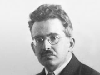Krauses Haar, runde Brille, strenger Blick: Walter Benjamin auf einer Schwarzweissaufnahme um 1928.