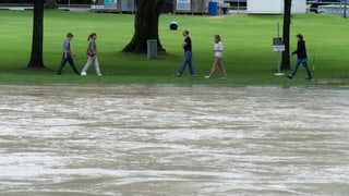 Platschvolles Aare-Flussbecken, am Ufer spatzieren Leute. Platschvolles Aare-Flussbecken, am Ufer spatzieren Leute.