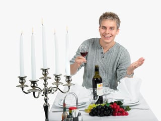 Reto Scherrer mit Weinglas am Tisch.