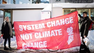 Protestierende am WEF 2019 in Davos halten ein Transparent in die Höhe. Protestierende am WEF 2019 in Davos halten ein Transparent in die Höhe.