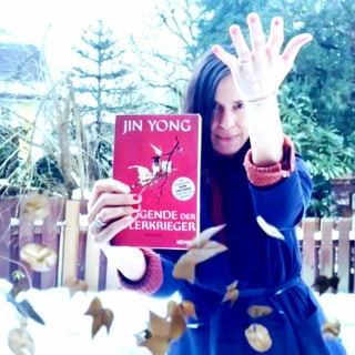 Annette König hält in der einen Hand «Die Legende der Adlerkrieger» von Jin Yong. Mit der anderen Hand erzeugt sie einen Wind, der Laubblätter in der Luft rotieren lässt. Annette König hält in der einen Hand «Die Legende der Adlerkrieger» von Jin Yong. Mit der anderen Hand erzeugt sie einen Wind, der Laubblätter in der Luft rotieren lässt.