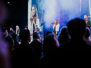 Publikum vor Bühne, darauf eine Leadsängerin vor LED-Screen Publikum vor Bühne, darauf eine Leadsängerin vor LED-Screen
