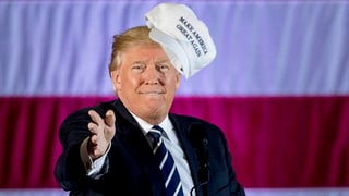 Trump wirft einen Hut in die Menge. Trump wirft einen Hut in die Menge.