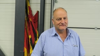 Portrait Marc Tobler vor eingerollten Berner Fahnen.