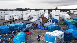 Blick auf das Flüchtlingslager in Calais: Im Vordergrund Zelte, im Hintergrund die neuen Metallcontainer