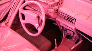 Auto von innen, ganz in Rosa gefärbt. 