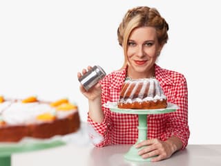 Moderatorin Myriam Zumbühl bestäubt einen Gugelhopf mit Puderzucker