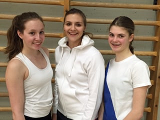 drei junge Frauen in Sportkleidern