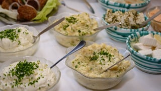 Schälchen mit Kartoffelsalat und Quarksauce  auf einem Buffet.