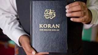 Zwei Hände halten einen Koran