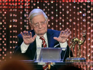 Schmidt auf einer Bühne, auf dem Tisch vor ihm steht das Bambi aus Gold.